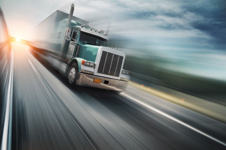 Photo of a semi truck speeding down the highway